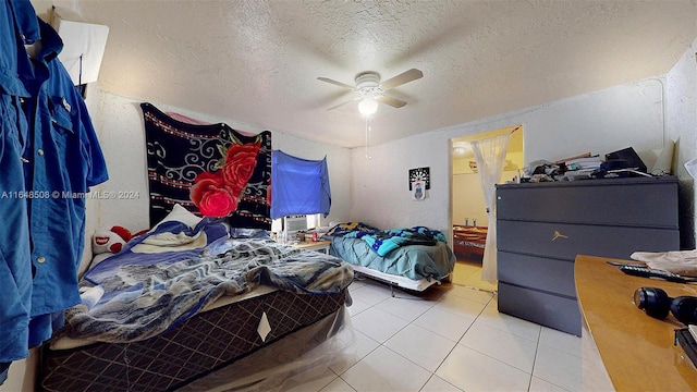 tiled bedroom featuring a textured ceiling, ensuite bath, and ceiling fan