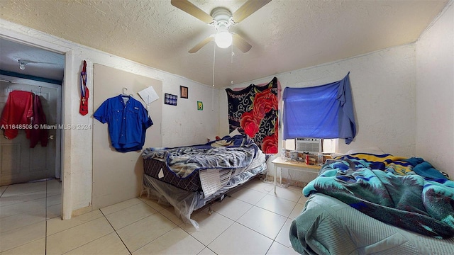 bedroom with light tile patterned floors, a textured ceiling, and ceiling fan