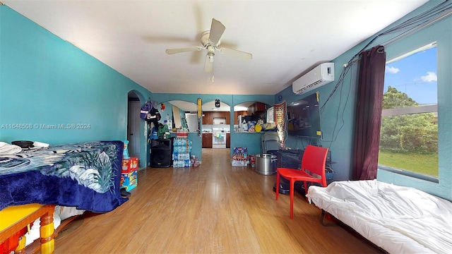 bedroom featuring ceiling fan, a wall mounted air conditioner, and hardwood / wood-style flooring