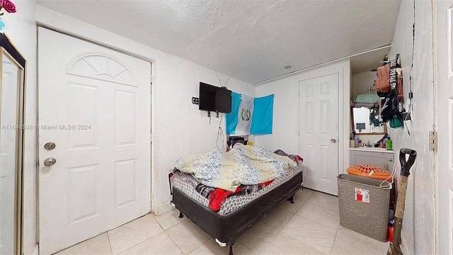 tiled bedroom with a textured ceiling