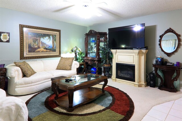 living room featuring a textured ceiling, light colored carpet, and ceiling fan