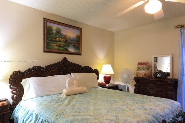 bedroom with ceiling fan and a textured ceiling