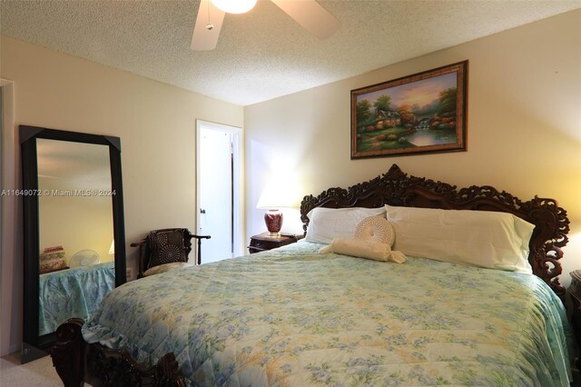 bedroom with a textured ceiling, carpet floors, and ceiling fan