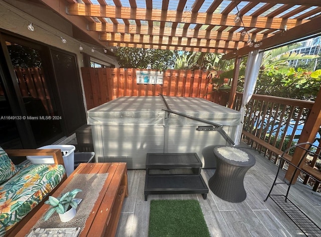 wooden terrace with a hot tub, outdoor dining area, and a pergola