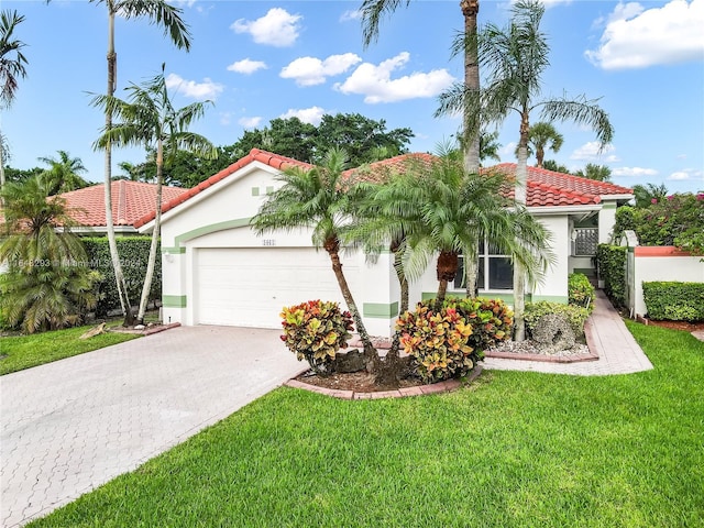 mediterranean / spanish home featuring a garage and a front yard