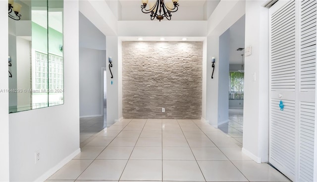 hallway featuring tile patterned flooring and a chandelier