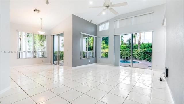 tiled empty room featuring high vaulted ceiling, visible vents, baseboards, and a ceiling fan