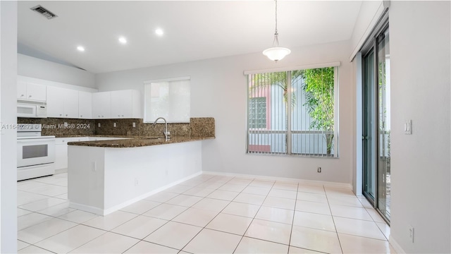 kitchen featuring light tile patterned floors, a peninsula, white appliances, white cabinetry, and backsplash