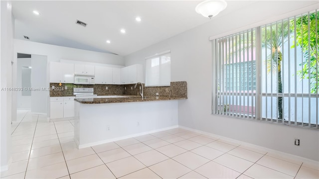 kitchen featuring white cabinets, light tile patterned floors, white appliances, kitchen peninsula, and tasteful backsplash