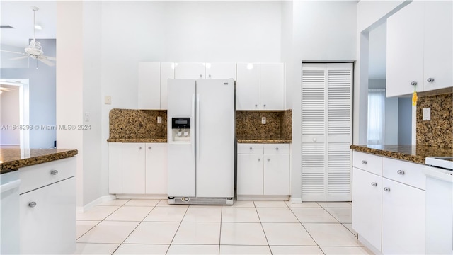 kitchen with white appliances, tasteful backsplash, light tile patterned floors, white cabinets, and ceiling fan