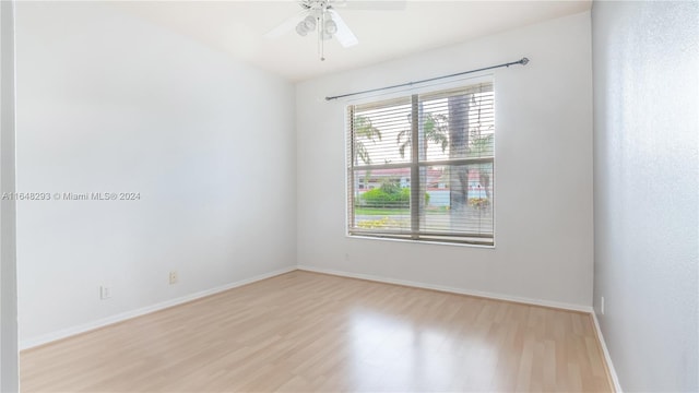 spare room with ceiling fan, wood finished floors, and baseboards