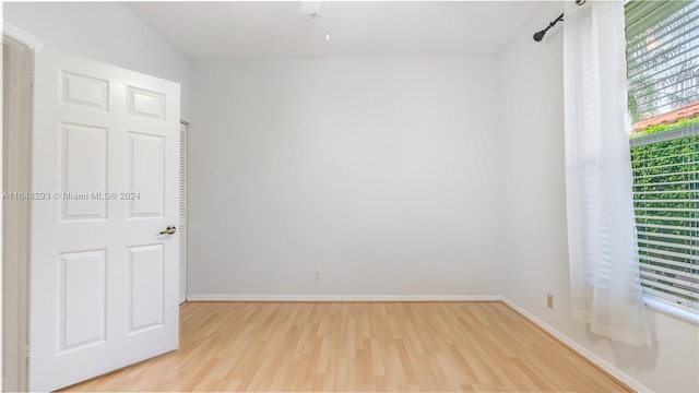 unfurnished room with baseboards and light wood finished floors