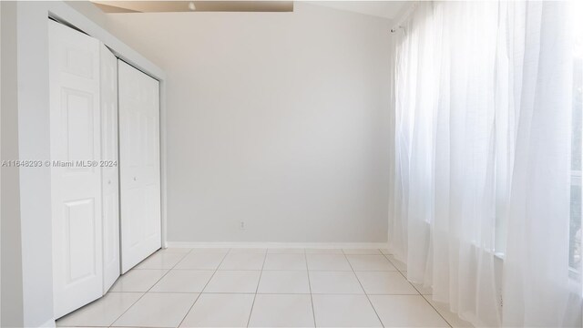 unfurnished bedroom with light tile patterned floors and a closet