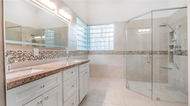 bathroom with tile patterned flooring, walk in shower, decorative backsplash, and vanity