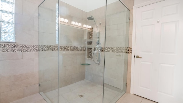 bathroom featuring tile patterned floors, tiled shower, and a healthy amount of sunlight