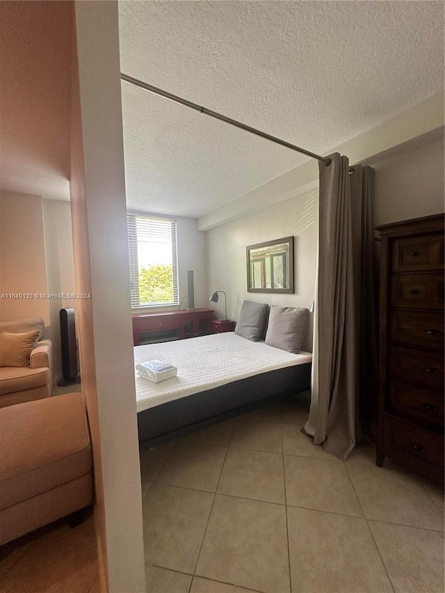 bedroom with light tile patterned floors and a textured ceiling