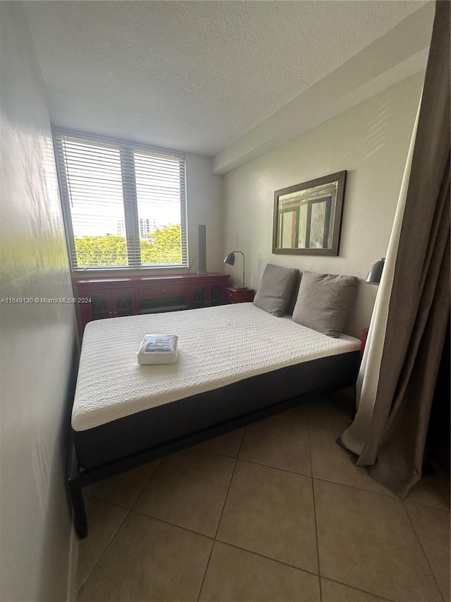 tiled bedroom with a textured ceiling