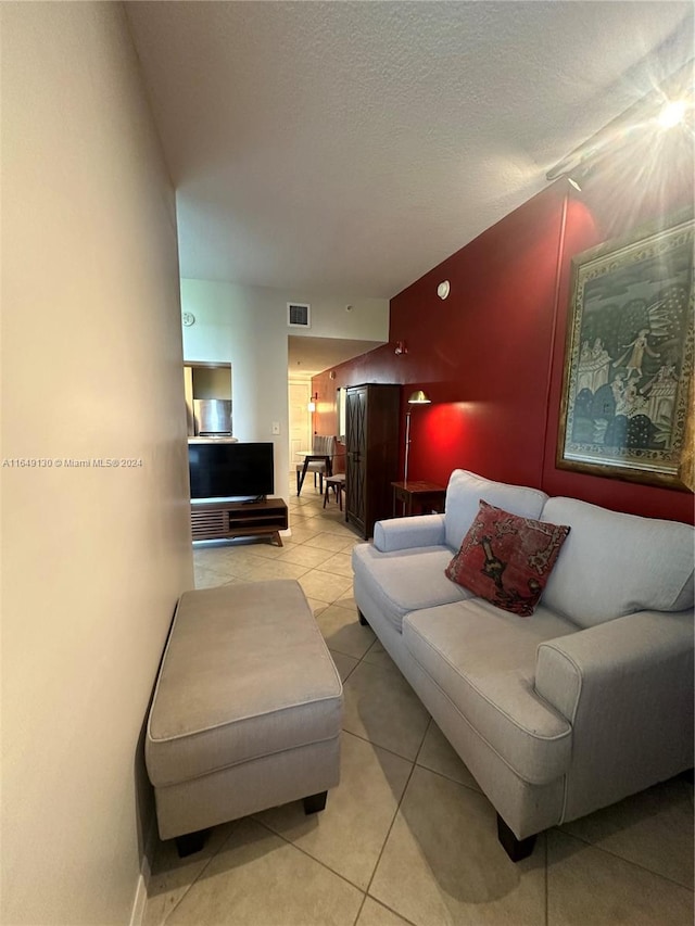 tiled living room featuring a textured ceiling