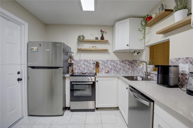 233 NE 14th Ave Unit 304, Hallandale Beach, FL 33009 - kitchen featuring stainless steel appliances, open shelves, a sink, light tile patterned floors, and white cabinetry