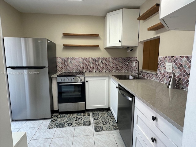 233 NE 14th Ave Unit 304, Hallandale Beach, FL 33009 - kitchen with appliances with stainless steel finishes, open shelves, a sink, white cabinetry, and tasteful backsplash