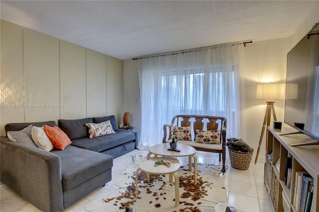 living room with a textured ceiling and light tile patterned flooring