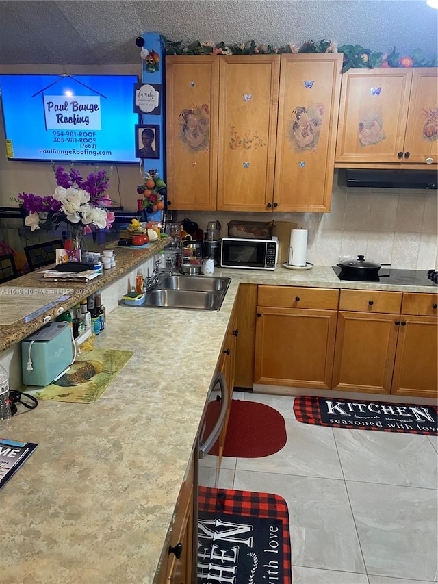 kitchen featuring sink, light tile patterned floors, and a textured ceiling