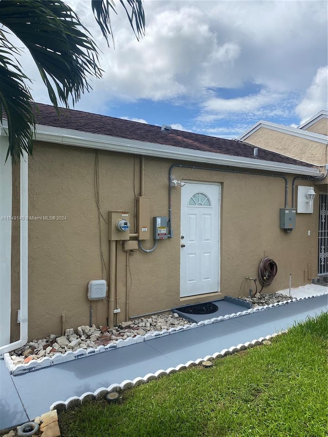 property entrance with a lawn