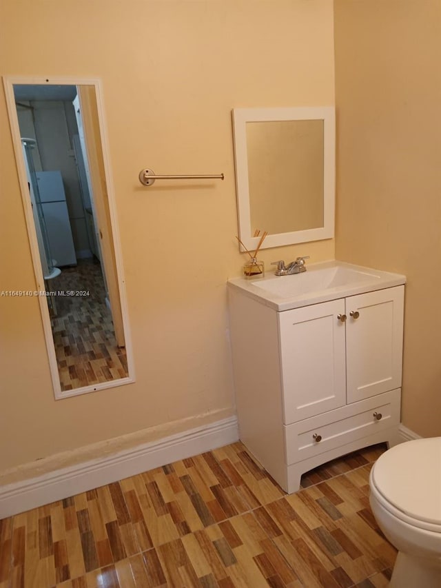 bathroom featuring hardwood / wood-style flooring, vanity, and toilet