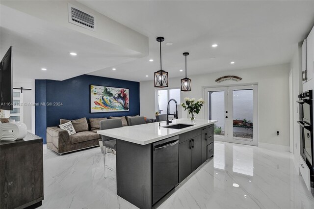 kitchen with light tile patterned flooring, sink, french doors, a kitchen island with sink, and stainless steel dishwasher