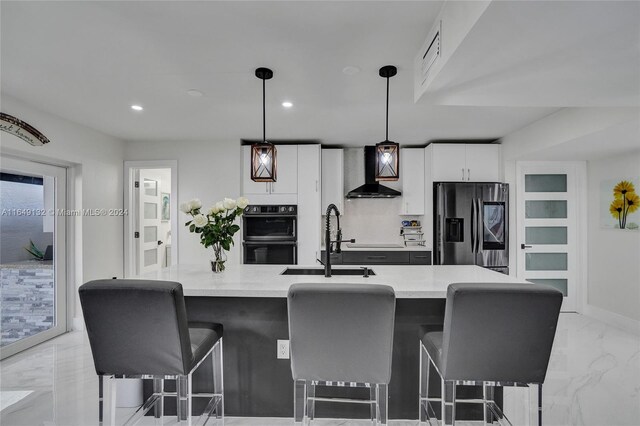 kitchen featuring white cabinetry, wall chimney range hood, light tile patterned floors, stainless steel fridge with ice dispenser, and hanging light fixtures