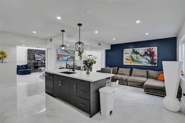 kitchen featuring light tile patterned flooring, black dishwasher, sink, an island with sink, and pendant lighting