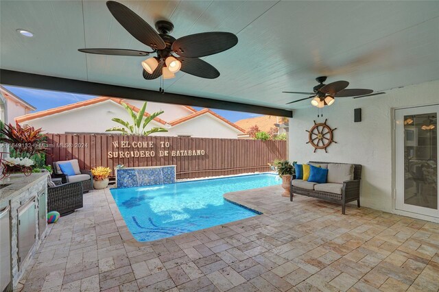 view of pool with ceiling fan, a patio, and pool water feature