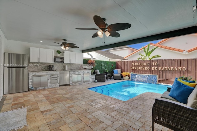 view of swimming pool featuring ceiling fan, area for grilling, a patio, and pool water feature