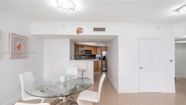 tiled dining room with ornamental molding