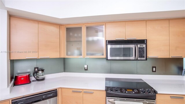 kitchen with dishwasher, light brown cabinetry, and double oven range