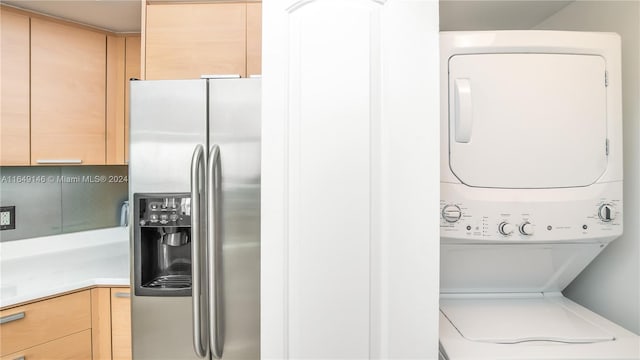 clothes washing area with stacked washer / dryer