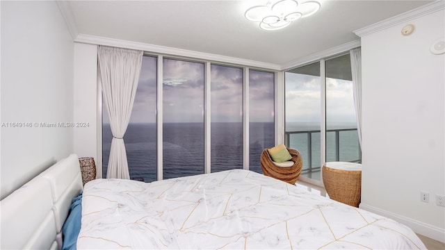 bedroom with ornamental molding, a water view, and expansive windows