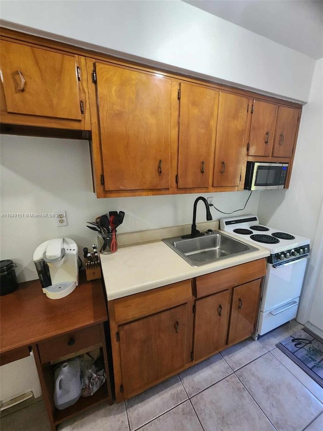 kitchen with white electric range, light tile patterned floors, and sink