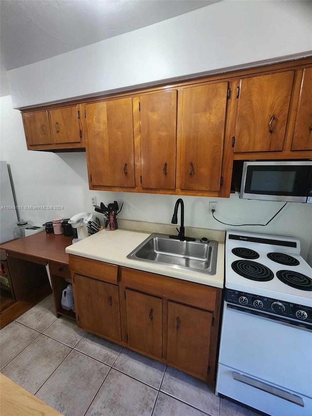 kitchen with white electric range, light tile patterned floors, and sink