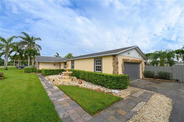 ranch-style home with a garage and a front lawn