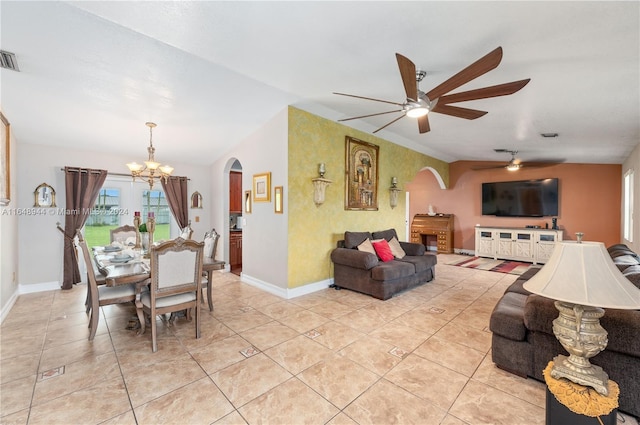 living room featuring baseboards, arched walkways, light tile patterned flooring, and ceiling fan with notable chandelier