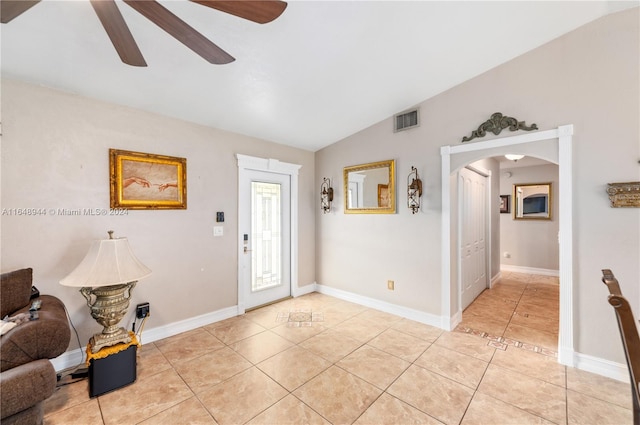 foyer with visible vents, light tile patterned floors, arched walkways, a ceiling fan, and lofted ceiling