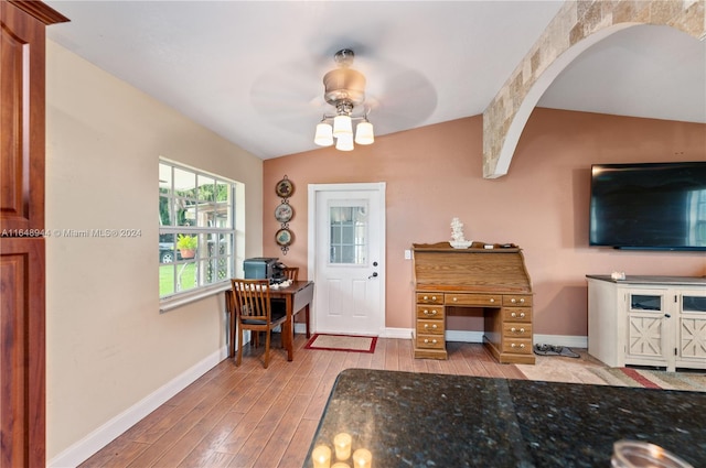 foyer with baseboards, arched walkways, ceiling fan, wood finished floors, and vaulted ceiling