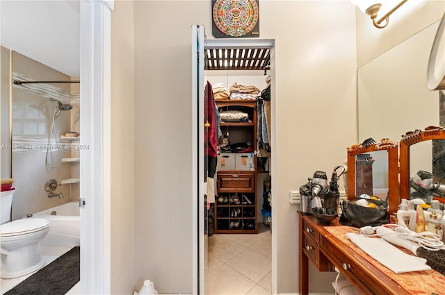 bathroom featuring vanity, shower / tub combination, toilet, a walk in closet, and tile patterned floors