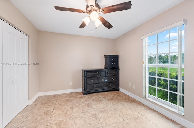 unfurnished bedroom featuring a closet, ceiling fan, and light tile patterned flooring