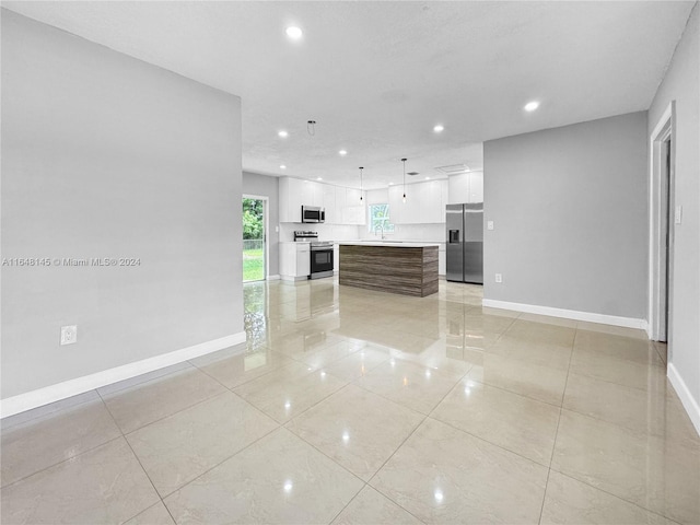 unfurnished living room featuring sink and light tile patterned flooring