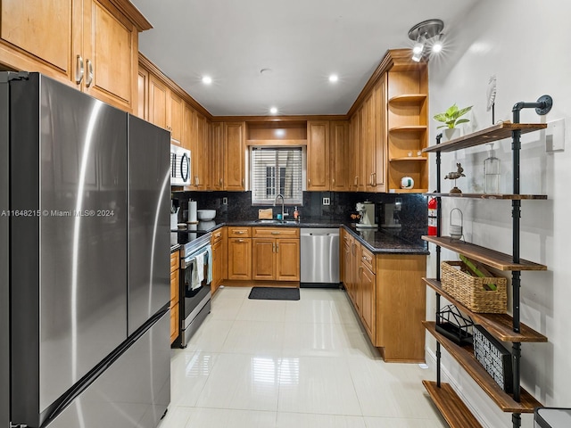 kitchen featuring dark stone countertops, backsplash, light tile patterned floors, sink, and appliances with stainless steel finishes