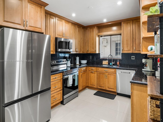 kitchen featuring appliances with stainless steel finishes, tasteful backsplash, light tile patterned floors, and sink