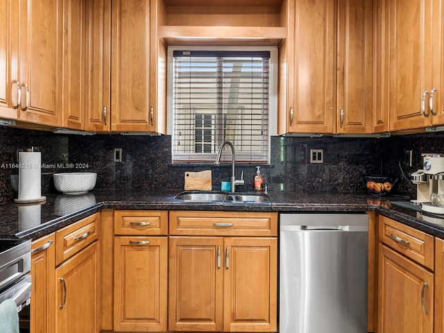 kitchen featuring dark stone countertops, tasteful backsplash, stainless steel dishwasher, and sink