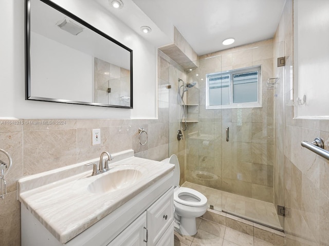 bathroom featuring vanity, a shower with shower door, tile walls, toilet, and tile patterned floors